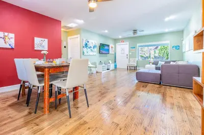 a dining room and living room with a table and a couch at Fun Family-Friendly Poolside Escape Near Beach in Dania Beach