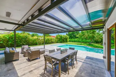 a patio with a table and chairs and a pool at Family-Friendly 4BR House with Pool in Westchester Miami in Tamiami