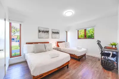 a bedroom with two beds and a desk and windows at Family-Friendly 4BR House with Pool in Westchester Miami in Tamiami