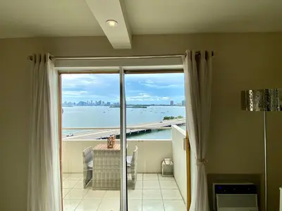 a room with a large glass door with a view of the water at Premium Modern waterfront apartment with Miami Skyline view on the bay 5 mins drive to Miami Beach with free parking in Miami Beach