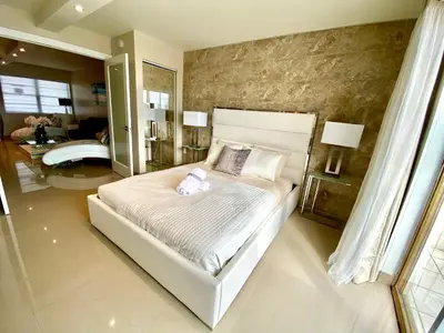 a bedroom with a white bed with a teddy bear on it at Premium Modern waterfront apartment with Miami Skyline view on the bay 5 mins drive to Miami Beach with free parking in Miami Beach
