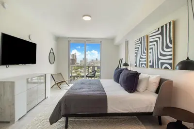 a bedroom with a large bed and a tv at Nomada Destination Residences - Quadro in Miami