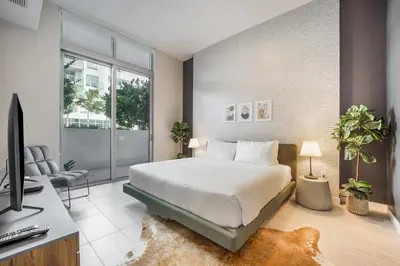a bedroom with a bed and a desk with a computer at Nomada Destination Residences - Quadro in Miami