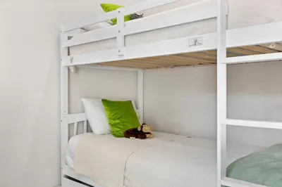 a white bunk bed with a teddy bear sitting on the bottom bunk at Casa Blanca of Miami º Families & Weekly Stays Close to Miami Beaches and the Keys West in Princeton