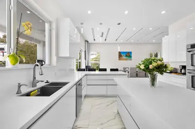 a white kitchen with a sink and a vase of flowers at Casa Blanca of Miami º Families & Weekly Stays Close to Miami Beaches and the Keys West in Princeton