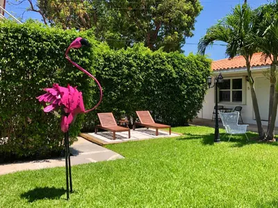 a pink bird statue in a yard with two chairs at The Oasis in Miami