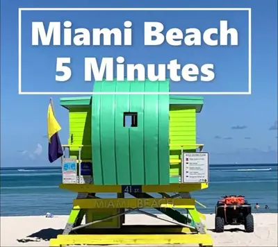 a beach life guard stand on the beach with the words main beach minutes at The Oasis in Miami