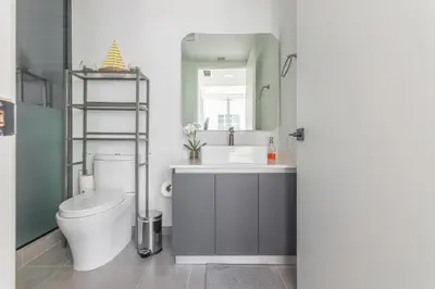 a bathroom with a toilet and a sink and a mirror at Amazing Condo in Downtown Miami/Brickell w/PARKING in Miami