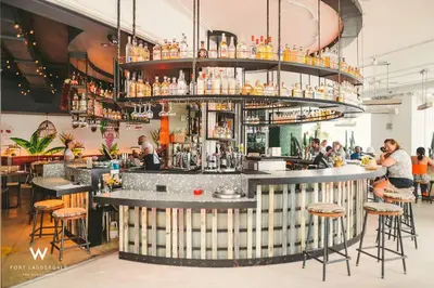 a bar in a restaurant with people standing around it at 1 Bedroom with ocean and city views! in Fort Lauderdale
