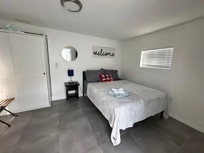 a bedroom with a bed and a window and a door at LYZ Miami Airport in Miami