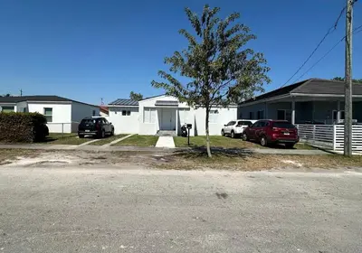 a house with two cars parked in a driveway at LYZ Miami Airport in Miami