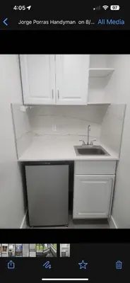 a kitchen with white cabinets and a sink at LYZ Miami Airport in Miami