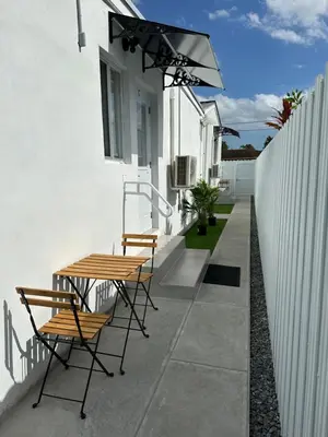 a patio with chairs and a table and a fence at LYZ Miami Airport in Miami