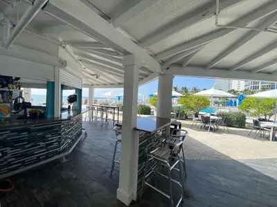 a white pergola with tables and chairs on a patio at Beachfront condo in Miami! in Sunny Isles Beach
