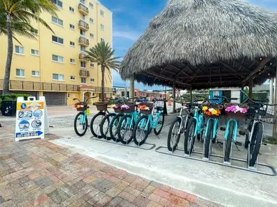 a row of bikes parked under a straw hut at Ocean Sound's Hotel in Hollywood
