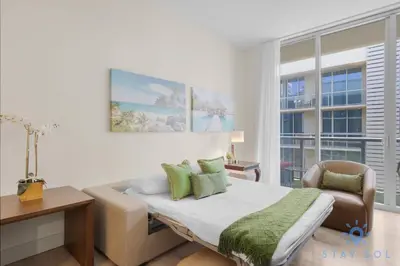 a bedroom with a bed with a chair and a window at Perfect Relax - Rooftop Pool - Gym - Hot Tub in Hollywood