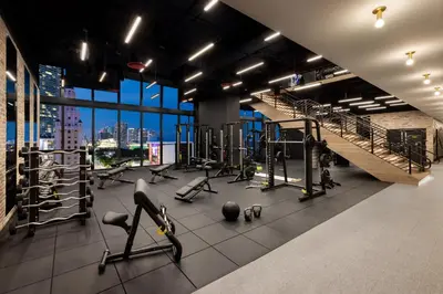 a gym with treadmills and weights in a building at The Elser Hotel Miami - An All-Suite Hotel in Miami