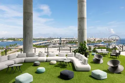 a living room with a white couch and tables and chairs at The Elser Hotel Miami - An All-Suite Hotel in Miami