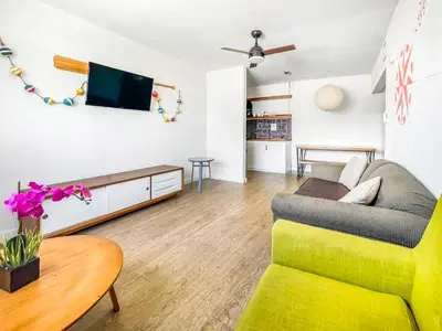 a living room with a couch and a tv at The Delmar in Hollywood