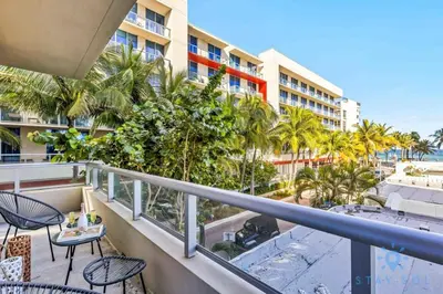 a balcony with chairs and tables and a view of the beach at Cozy Apartment - Hot Tub - NearBeach - Broad - walk in Hollywood