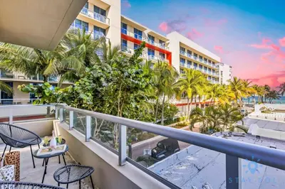 a balcony with a view of the beach and palm trees at Cozy Apartment - Hot Tub - NearBeach - Broad - walk in Hollywood