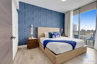 a bedroom with a bed with a blue accent wall at Exclusive Apartment - Rooftop Pool - Hollywood Beach in Hollywood