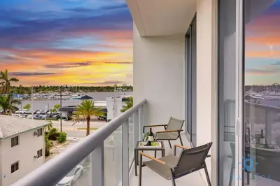 a balcony with chairs and a table and a view of a harbor at Exclusive Apartment - Rooftop Pool - Hollywood Beach in Hollywood