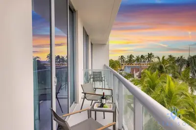 a balcony with a view of the ocean and palm trees at Exclusive Apartment - Rooftop Pool - Hollywood Beach in Hollywood
