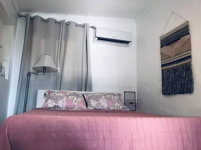 a bedroom with a bed with pink sheets and a lamp at Private and Comfy Cabin near to MIA airport in Miami