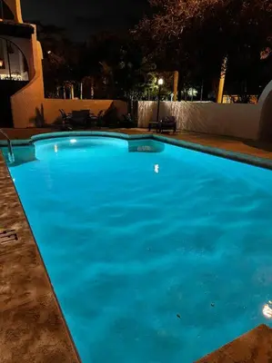 a large blue swimming pool at night at Villa at St. James Place “H”, Luxury, Pet Friendly in Miami