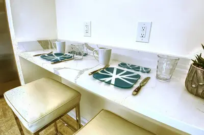 a white counter with a table with plates on it at Villa at St. James Place “H”, Luxury, Pet Friendly in Miami