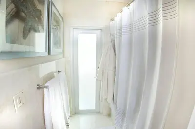 a bathroom with a white shower curtain and a window at Villa at St. James Place “H”, Luxury, Pet Friendly in Miami