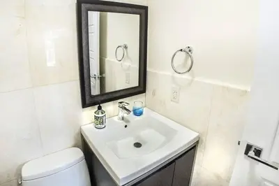 a white bathroom with a sink and a mirror at Villa at St. James Place “H”, Luxury, Pet Friendly in Miami