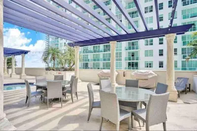a patio with a table and chairs and a building at 40th floor Ocean View - Best Location in Miami