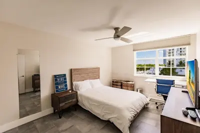 a bedroom with a bed and a desk and a window at Uhost AI - 3BR Condo - Stunning Water Views in Miami