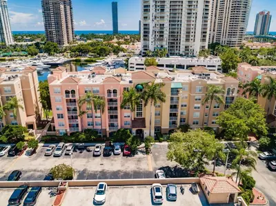 an aerial view of a building with cars parked in a parking lot at Uhost AI - 3BR Condo - Stunning Water Views in Miami