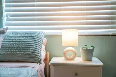 a lamp on a night stand next to a bed at Cozy Room near Miami Airport in Miami