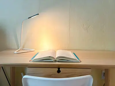 an open book sitting on a desk with a lamp at Cozy Room near Miami Airport in Miami