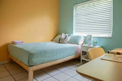 a small bedroom with a bed and a window at Cozy Room near Miami Airport in Miami