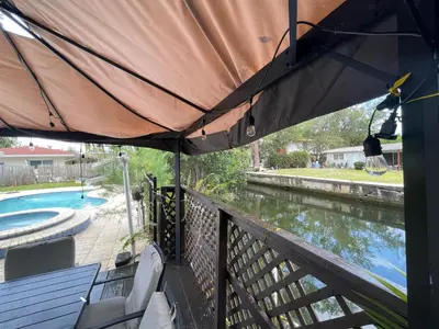 a patio with an umbrella and a swimming pool at Pool House on the Water 2 in Miami