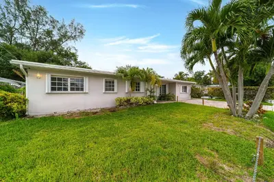 a house with a palm tree in a yard at Pool House on the Water 2 in Miami