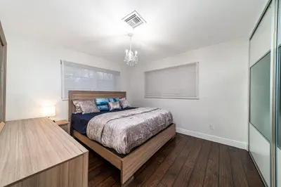 a bedroom with a bed and a chandelier at Pool House on the Water 2 in Miami
