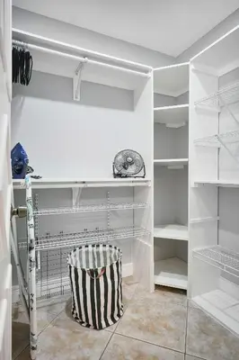 a white walk in closet with a black and white stool at Vacay Spot Gables 4 to 23 Guest GameRoom 2 Kitchens 2 BBQ, 2 BAR, Backyard, Patio, Prime LOC! 6 blocks away from Bars, Nite Clubs, Res, Shops in Miami