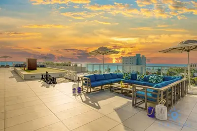 a patio with blue couches and umbrellas on a roof at Rooftop infinity Pool - Hollywood Beach Broad - walk in Hollywood