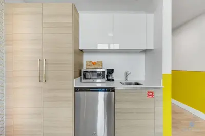 a kitchen with white cabinets and a stainless steel refrigerator at Hollywood Beach Broad - walk - Gym - Amazing Pool in Hollywood
