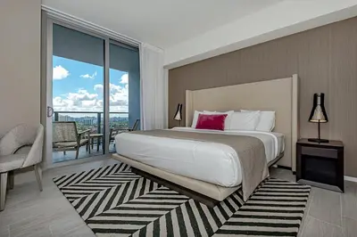 a bedroom with a large bed and a balcony at Wrap Around Balcony - 2Br - Amazing Views - Pools in Hollywood