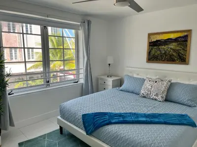 a bedroom with a bed and a large window at Direct Ocean View - Luxurious condo in South Beach in Miami Beach