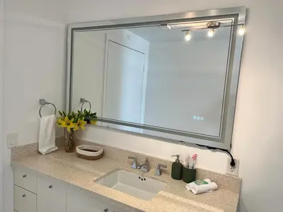 a bathroom with a sink and a large mirror at Direct Ocean View - Luxurious condo in South Beach in Miami Beach