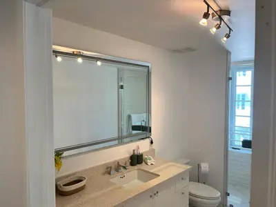 a bathroom with a sink and a mirror and a toilet at Direct Ocean View - Luxurious condo in South Beach in Miami Beach