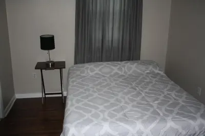 a bedroom with a bed and a table with a lamp at Key West Style Historic Home in Coconut Grove Florida, The Blue House in Miami